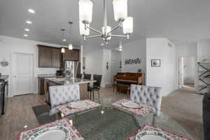 Carpeted dining area with a notable chandelier and sink