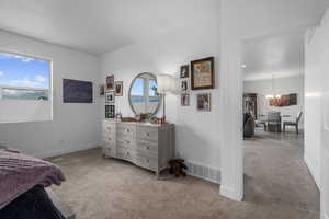 Carpeted bedroom with a notable chandelier