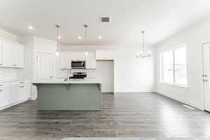 Kitchen featuring recessed lighting, a chandelier, appliances with stainless steel finishes, a sink, and white cabinetry