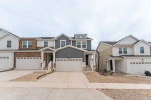 Townhome / multi-family property with brick siding and driveway