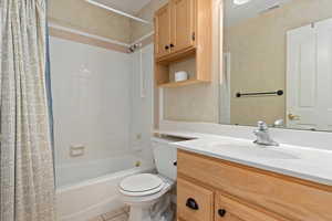 Full bathroom featuring tile patterned floors, vanity, shower / bath combo, and toilet