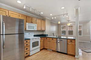 Kitchen with crown molding, ceiling fan, sink, and stainless steel appliances