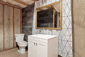 Bathroom with vanity, toilet, and concrete floors