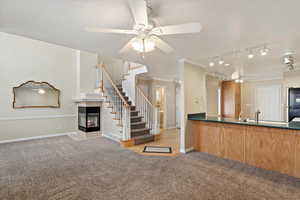 Kitchen featuring ceiling fan, stainless steel fridge, light colored carpet, and crown molding