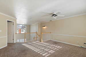 Unfurnished room featuring a textured ceiling, ceiling fan, carpet floors, and crown molding