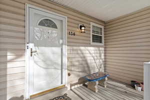 Doorway to property featuring covered porch