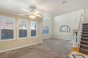 Carpeted spare room with ceiling fan and crown molding