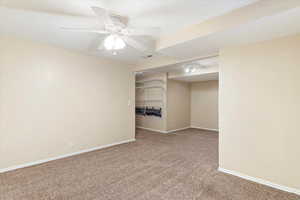 Empty room with ceiling fan and carpet floors