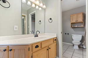 Bathroom featuring tile patterned flooring, vanity, and toilet