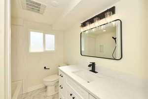 Full bathroom featuring shower / tub combination, vanity, and toilet