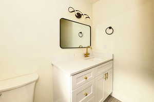 Bathroom featuring tile patterned floors, vanity, and toilet