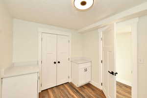 Hallway featuring dark hardwood / wood-style flooring and a textured ceiling