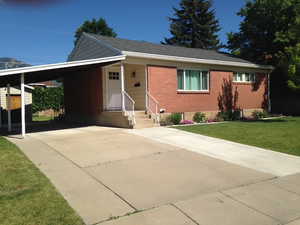 View of front of home featuring a front yard and a carport