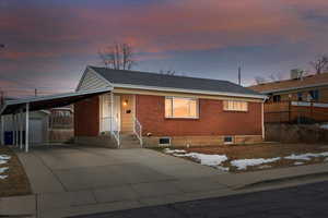 View of front of property featuring a carport and an outbuilding