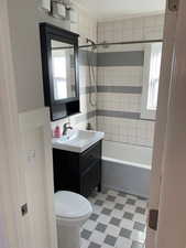 Full bathroom with vanity, tiled shower / bath, and toilet