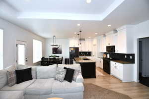 Living room with light wood-type flooring and sink