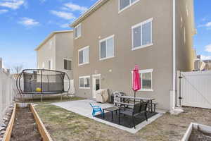 Rear view of property featuring a patio area and a trampoline