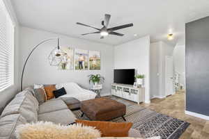 Living room with light hardwood / wood-style flooring and ceiling fan