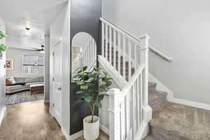 Stairway featuring hardwood / wood-style floors, a textured ceiling, and ceiling fan