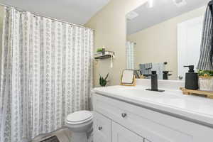 Bathroom featuring tile patterned flooring, vanity, and toilet