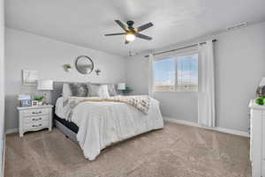 Carpeted bedroom featuring ceiling fan