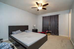 Carpeted bedroom featuring ceiling fan