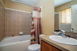 Full bathroom featuring shower / tub combo, vanity, and toilet