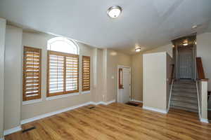 Empty room featuring light hardwood / wood-style flooring and lofted ceiling