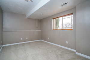 Spare room with light carpet and a textured ceiling