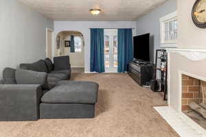 Living room with carpet flooring and a textured ceiling