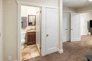 Bathroom featuring a textured ceiling, vanity, and toilet