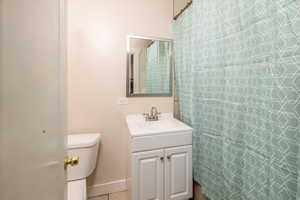 Bathroom featuring tile patterned floors, vanity, and toilet