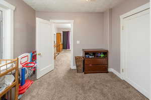 Bedroom featuring carpet floors and a textured ceiling