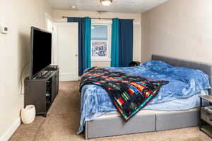 Carpeted bedroom with a textured ceiling