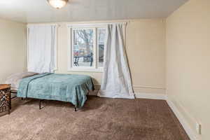 Bedroom with carpet and a textured ceiling