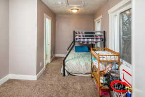 Bedroom featuring carpet floors and a textured ceiling