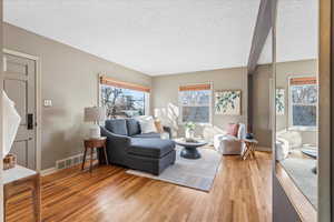 Living room featuring plenty of natural light, a textured ceiling, and hardwood / wood-style flooring