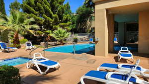 View of swimming pool featuring a community hot tub and a patio