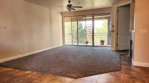 Unfurnished room featuring carpet floors and ceiling fan