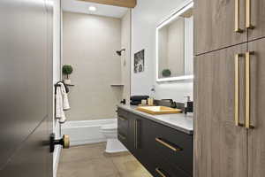 Full bathroom featuring tile patterned flooring, vanity, toilet, and tiled shower / bath