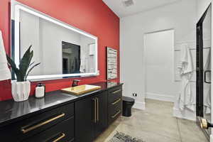 Bathroom with vanity, toilet, and an enclosed shower