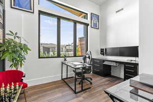 Office space with dark hardwood / wood-style flooring