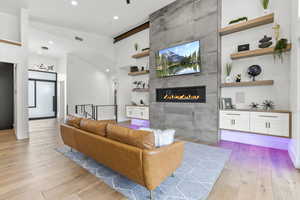 Living room with a fireplace and light hardwood / wood-style flooring