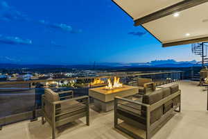 Patio terrace at dusk featuring a fire pit and a mountain view