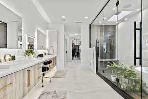 Bathroom featuring a skylight, vanity, and an enclosed shower