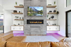 Bar with a fireplace, light hardwood / wood-style floors, and white cabinetry