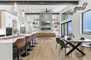 Dining space featuring ceiling fan, a fireplace, and light hardwood / wood-style floors