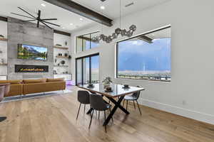 Dining area with ceiling fan, light wood-type flooring, and a tiled fireplace