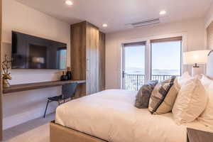 Bedroom featuring access to exterior, a mountain view, and light colored carpet