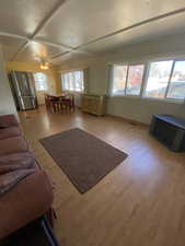 Living room featuring light hardwood / wood-style floors, ceiling fan, and coffered ceiling